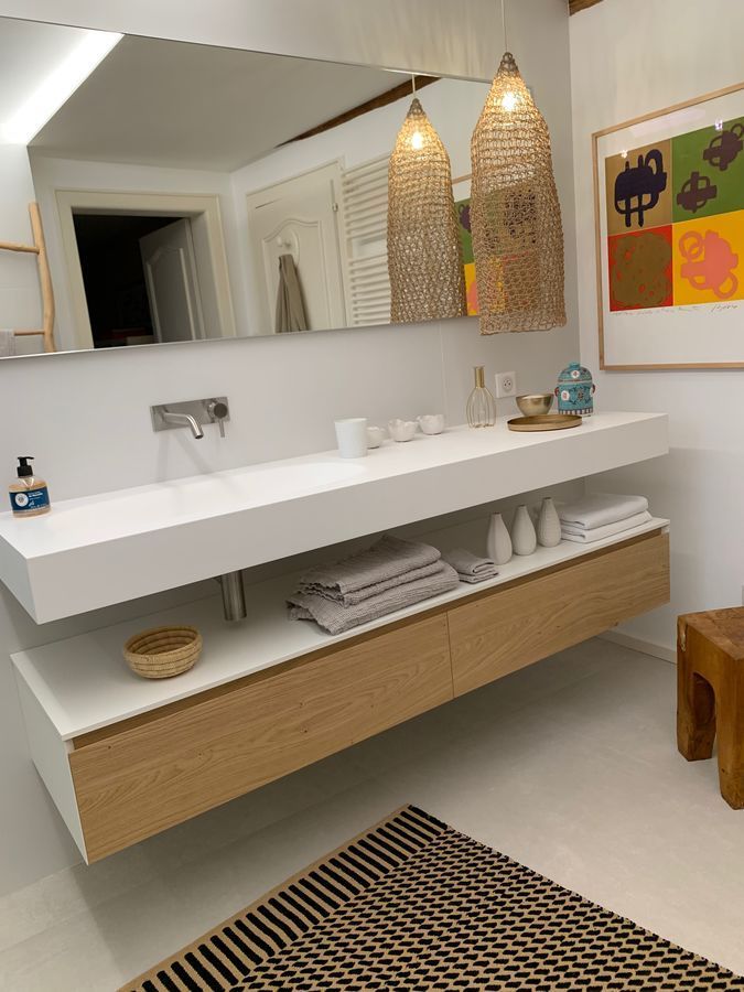 Une salle de bain avec deux lavabos et un grand miroir