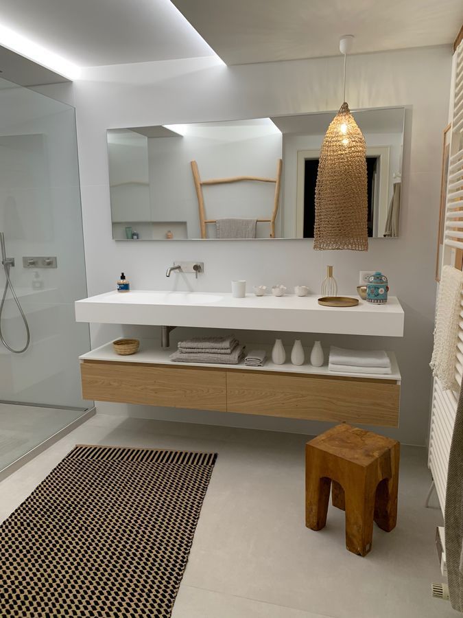 Une salle de bain avec deux lavabos et un tabouret en bois