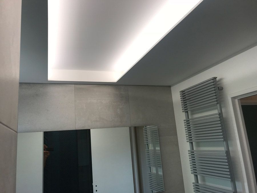 Une salle de bain avec un plafonnier et un porte-serviettes.