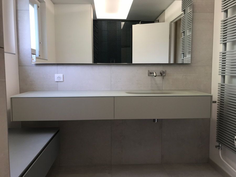 Une salle de bain avec un lavabo et un grand miroir