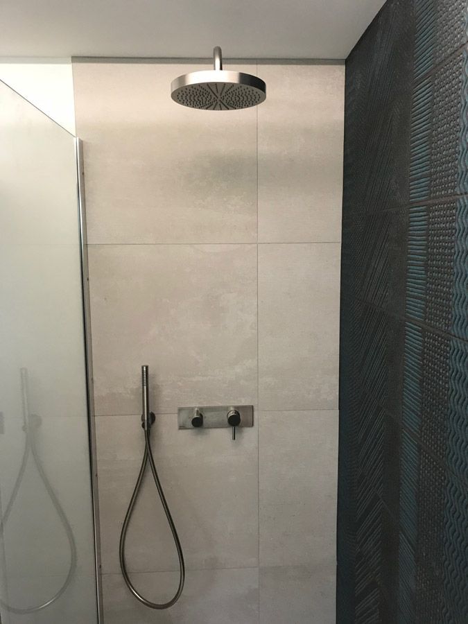 Une pomme de douche est suspendue au plafond dans une salle de bain.
