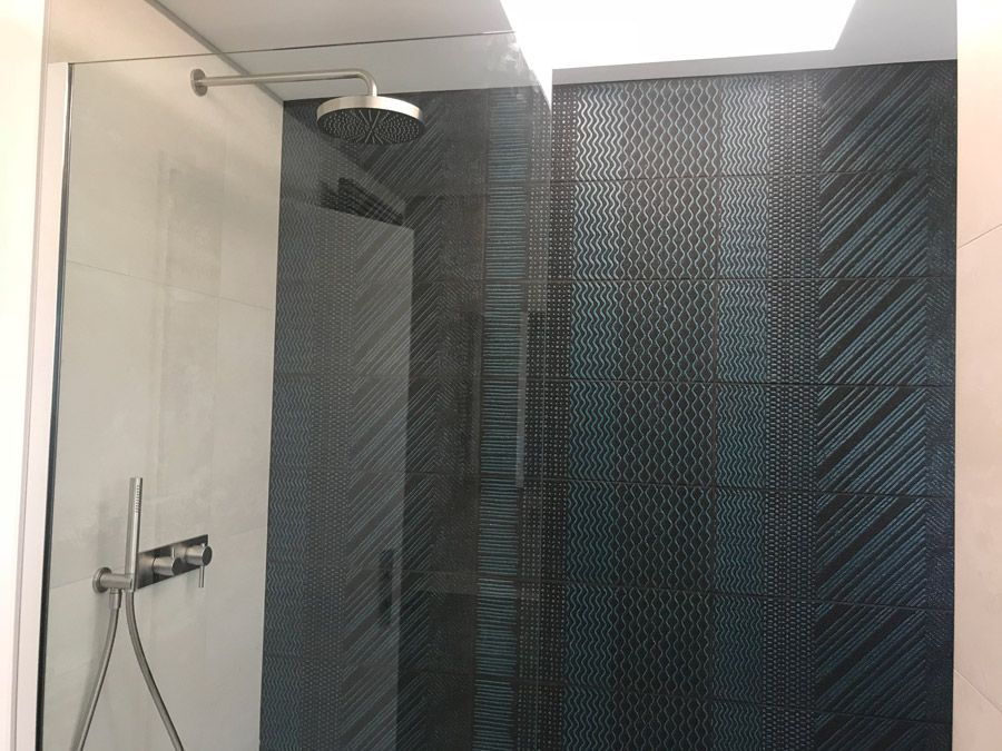 Une salle de bain avec douche à l'italienne et pommeau de douche.