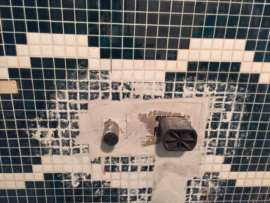 Un mur carrelé bleu et blanc avec un robinet dessus