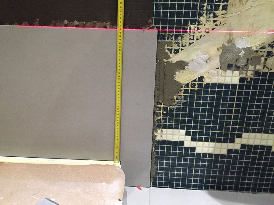 Un ruban à mesurer est utilisé pour mesurer un mur carrelé