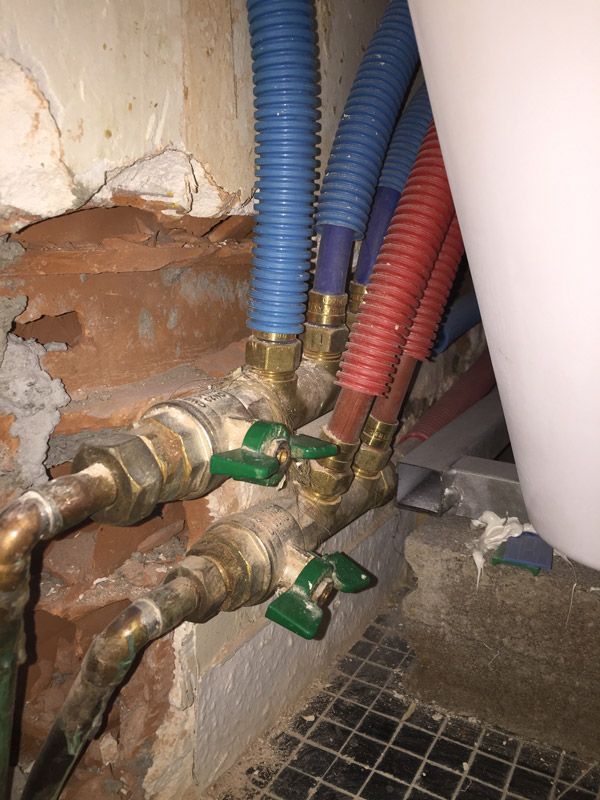 Un tas de tuyaux sont reliés à un mur