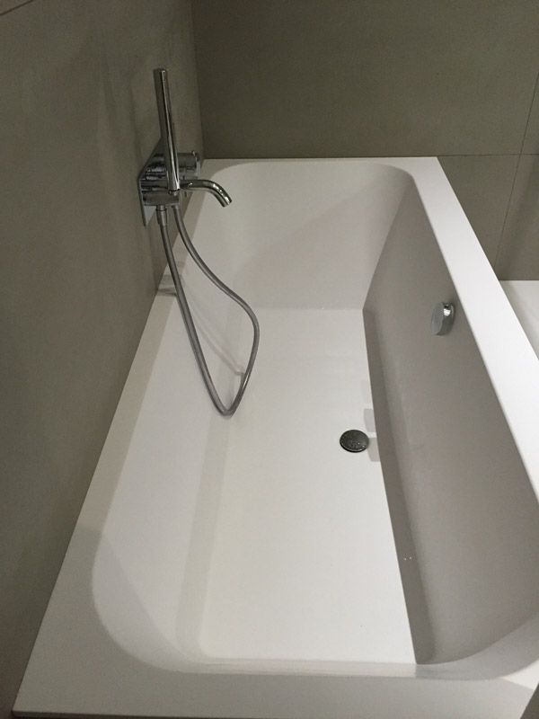 Une baignoire avec une pomme de douche attachée