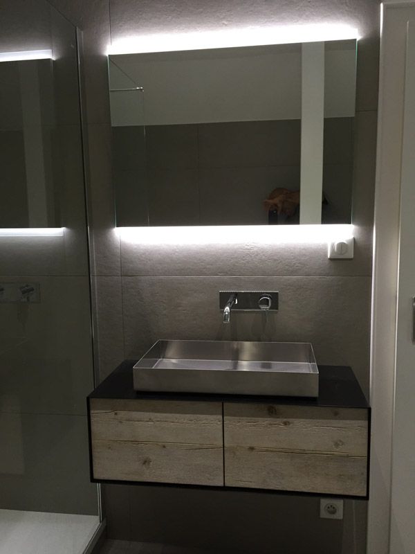Une salle de bain avec un lavabo et un miroir.