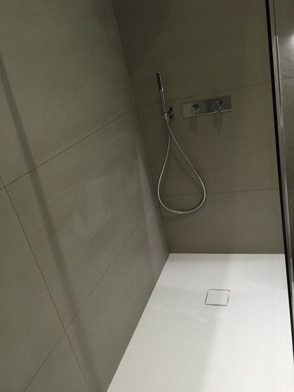 Une salle de bain avec une cabine de douche et un pommeau de douche.