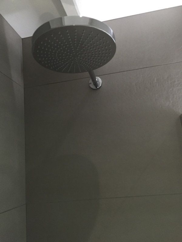 Une pomme de douche est suspendue au plafond d'une salle de bain.