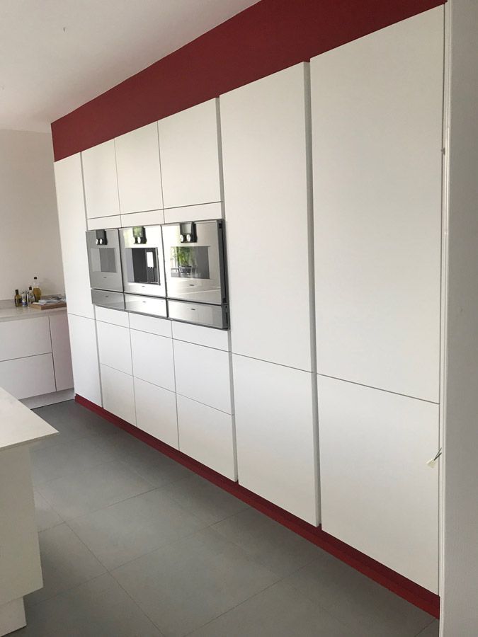 Une cuisine avec des armoires blanches et des appareils en acier inoxydable