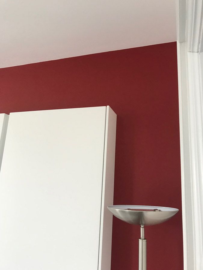 Une lampe est posée devant un mur rouge