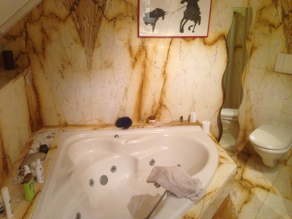 Une salle de bain avec baignoire jacuzzi et toilettes