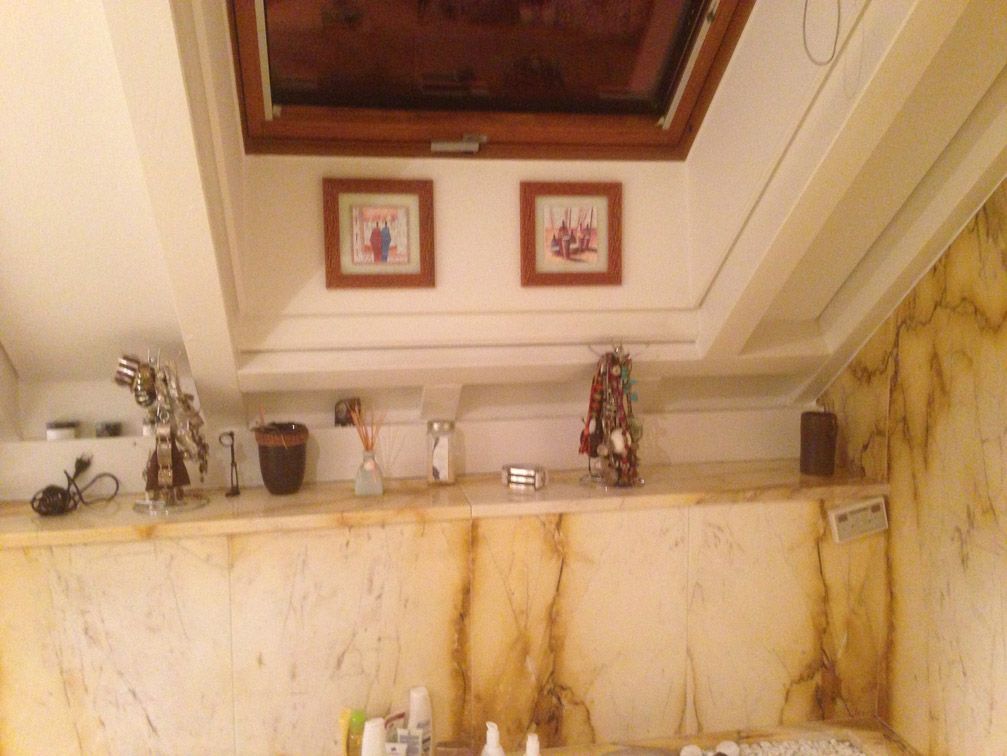 Une salle de bain avec un puits de lumière au-dessus du lavabo