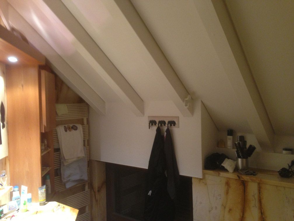 Une pièce avec un plafond sur lequel se trouvent quelques crochets