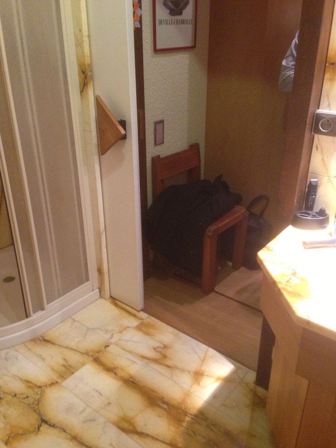 Une salle de bain avec un sol en marbre et une chaise