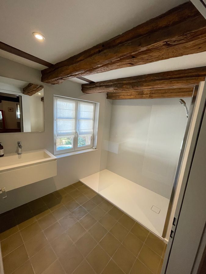 Une salle de bain avec un lavabo et une douche à l'italienne.