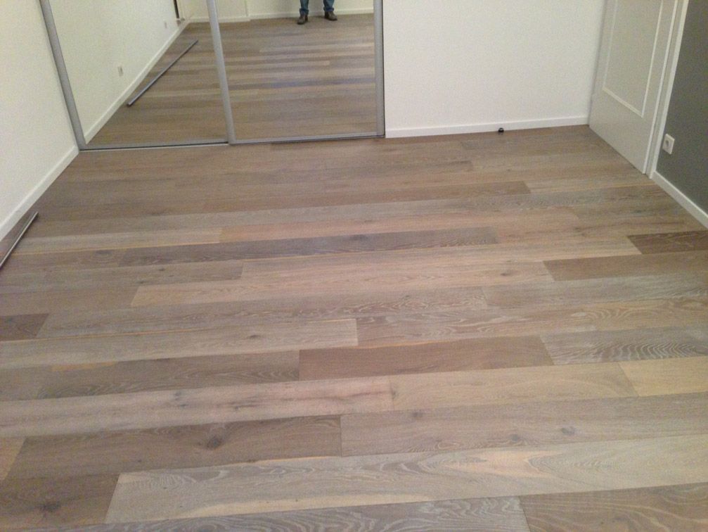 Une pièce avec un parquet et un miroir