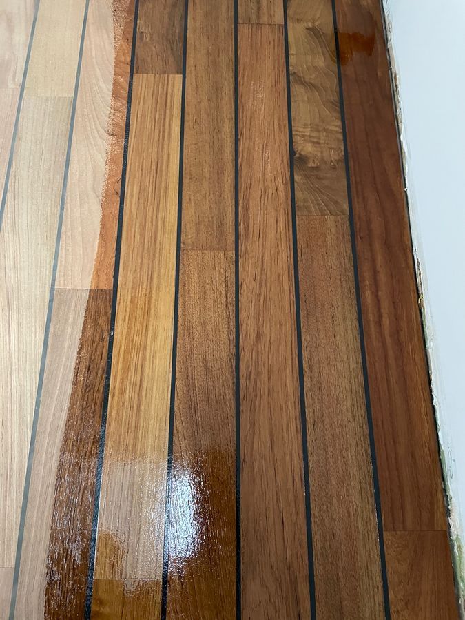 Un gros plan d'un plancher en bois avec un mur blanc en arrière-plan.