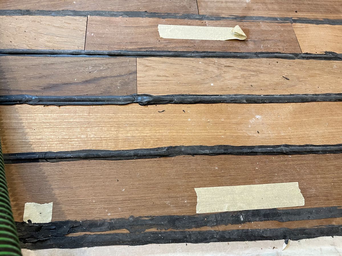 Un gros plan d'un plancher en bois avec du ruban adhésif dessus.