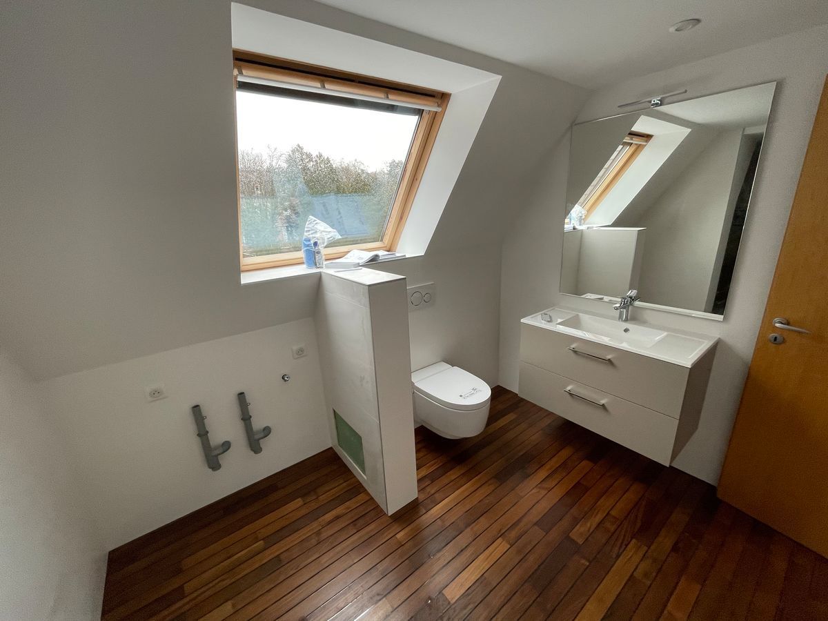 Une salle de bain avec des toilettes, un lavabo et une fenêtre