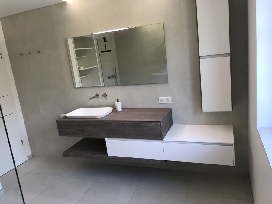 Une salle de bain avec un lavabo, un miroir et des armoires.