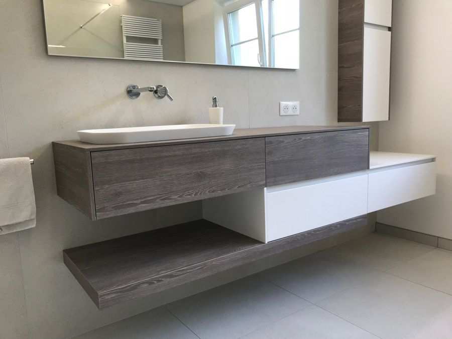 Une salle de bain avec un lavabo et un miroir au mur.