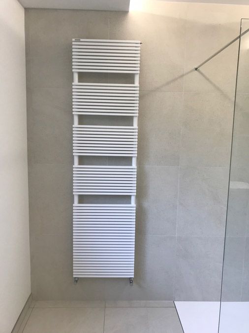 Une salle de bain avec un porte-serviettes blanc accroché au mur