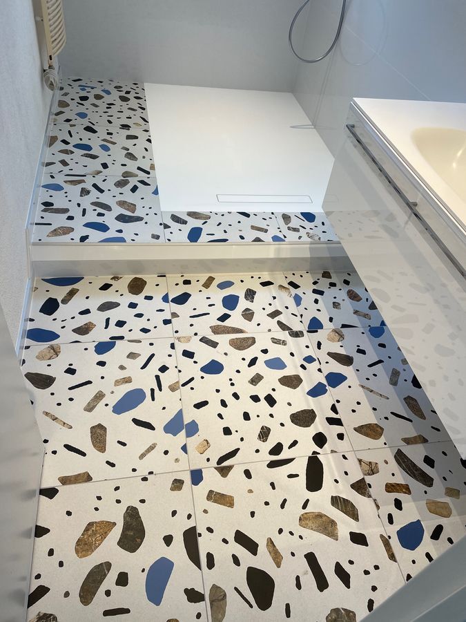 Une salle de bain avec un sol en terrazzo et une douche