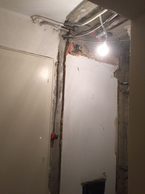 Une pièce avec une lumière suspendue au plafond et une porte.