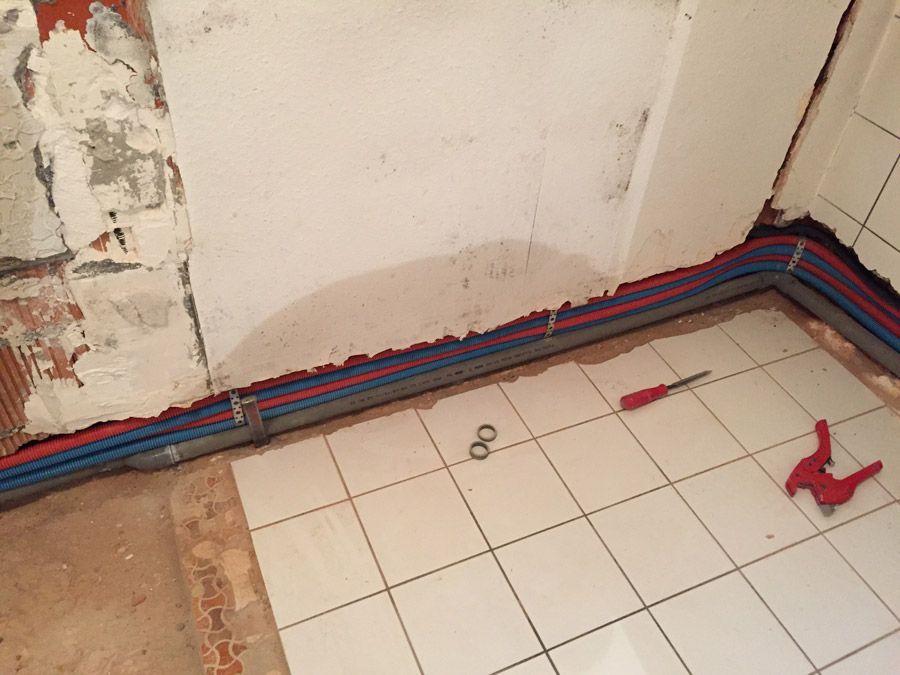 Une salle de bain en construction avec un tournevis et des ciseaux sur le sol