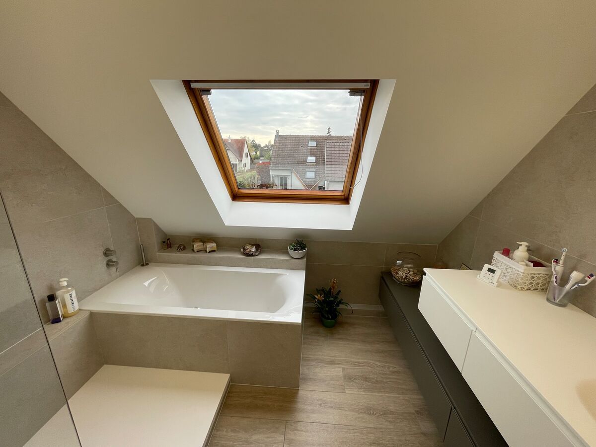 Une salle de bain avec un puits de lumière au-dessus de la baignoire