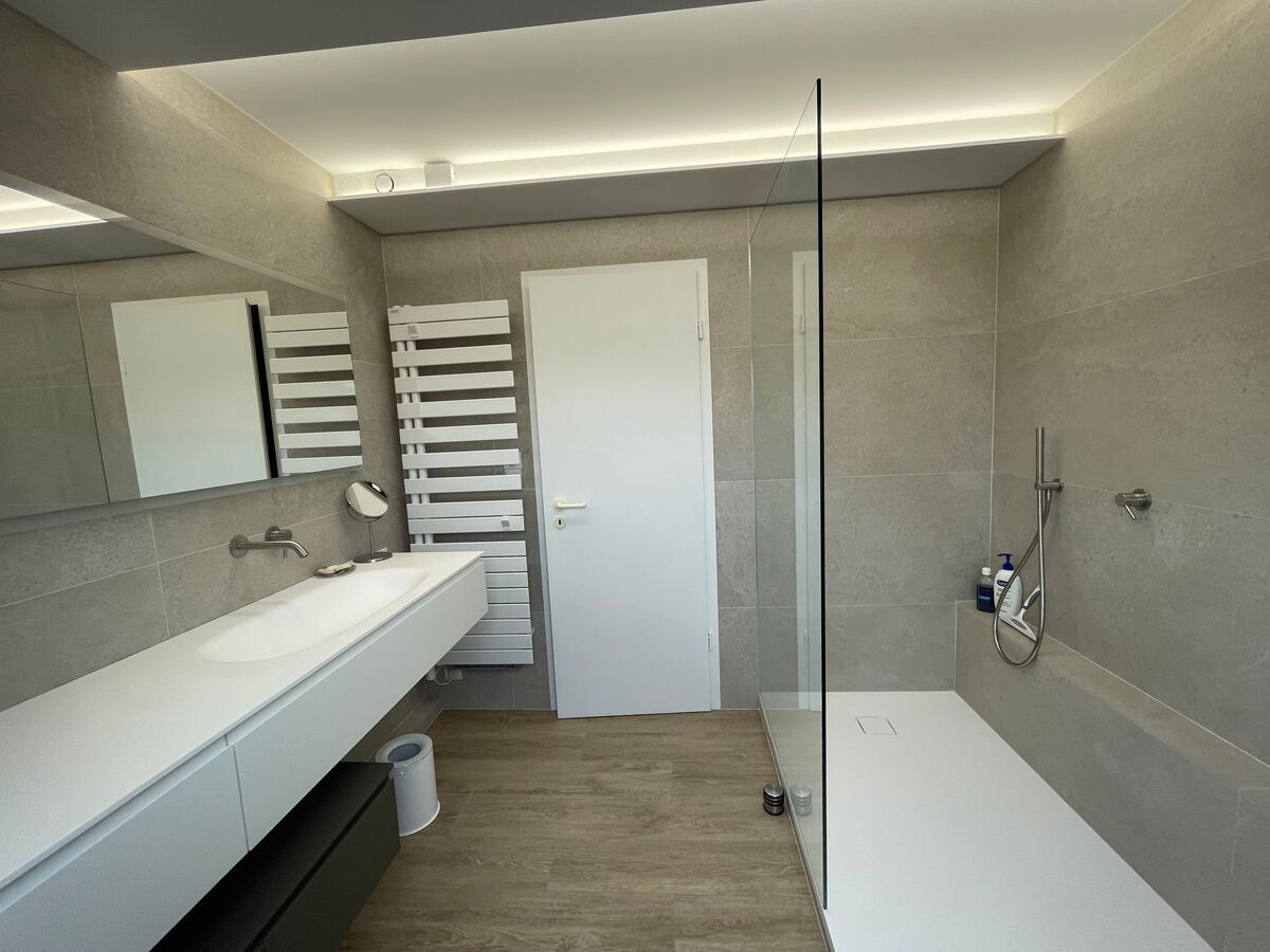 Une salle de bain avec une douche à l'italienne et un lavabo