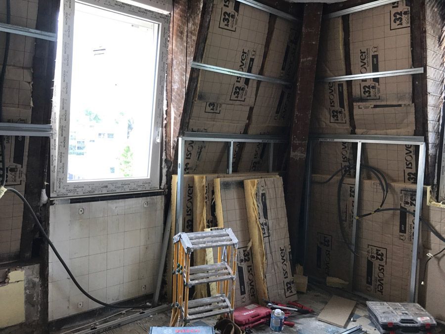 Une pièce avec une fenêtre et une échelle à l'intérieur.