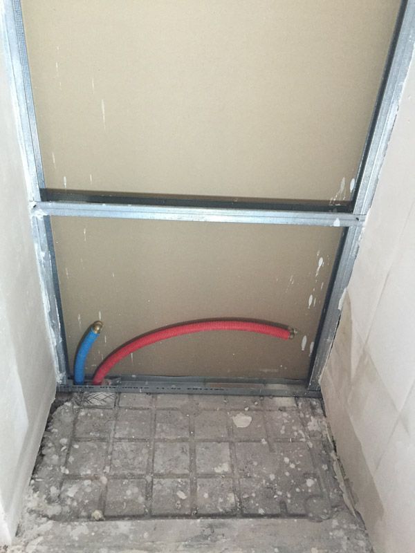 Une pièce avec un plafond et quelques tuyaux qui en sortent.