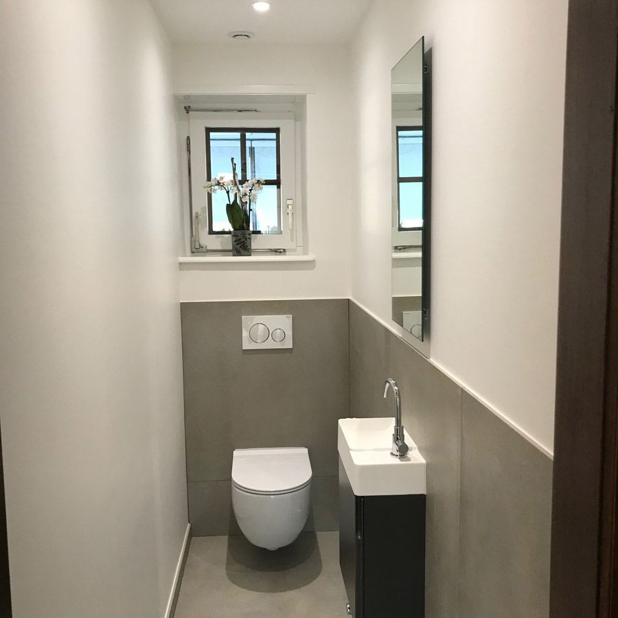 Une petite salle de bain avec WC, lavabo et miroir.