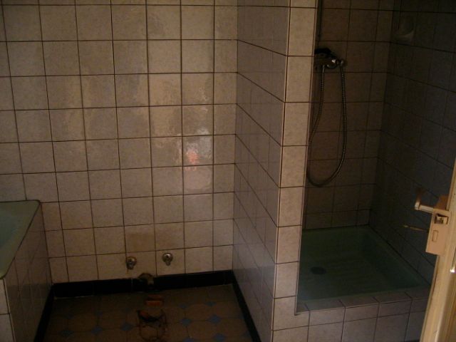 Une salle de bain avec carrelage blanc et douche.