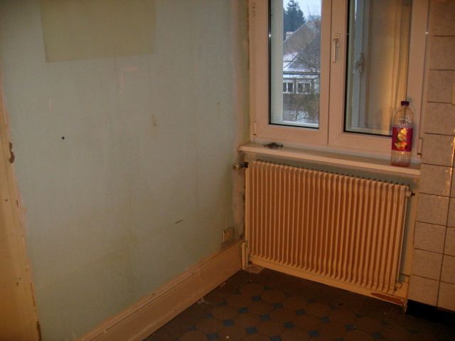 Une pièce vide avec un radiateur et une fenêtre.