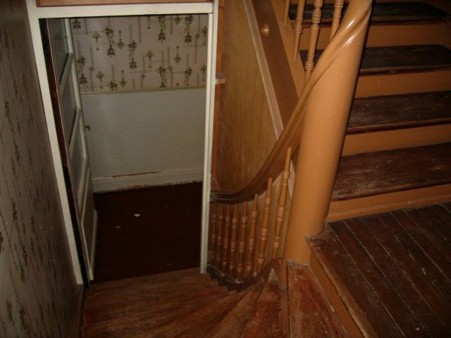 Un escalier en colimaçon en bois avec une rampe blanche