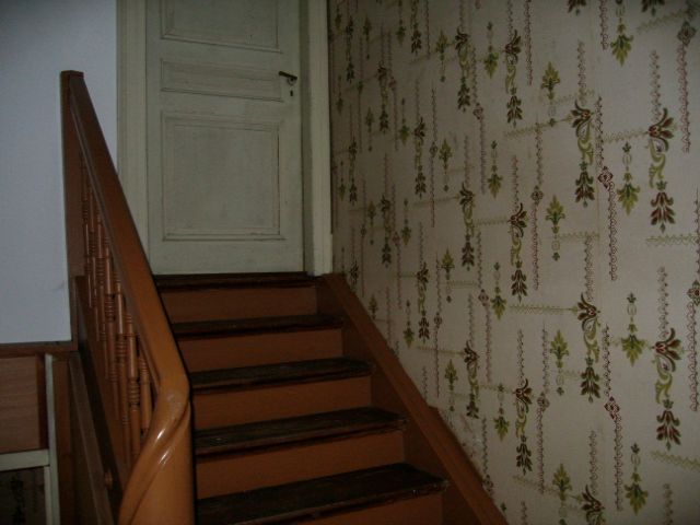 Un escalier avec un papier peint floral sur le mur
