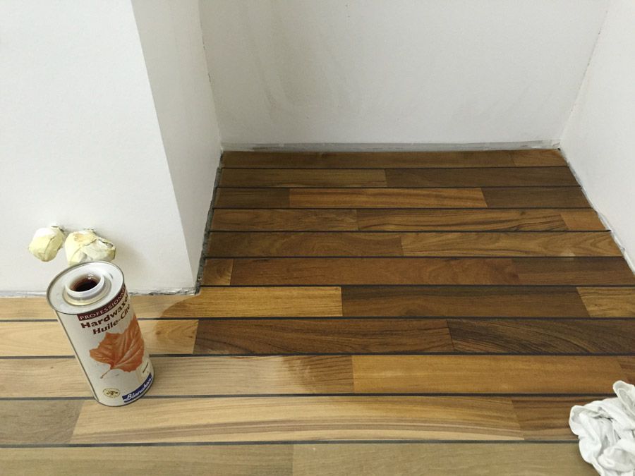 Une bombe de peinture est posée sur un plancher en bois.