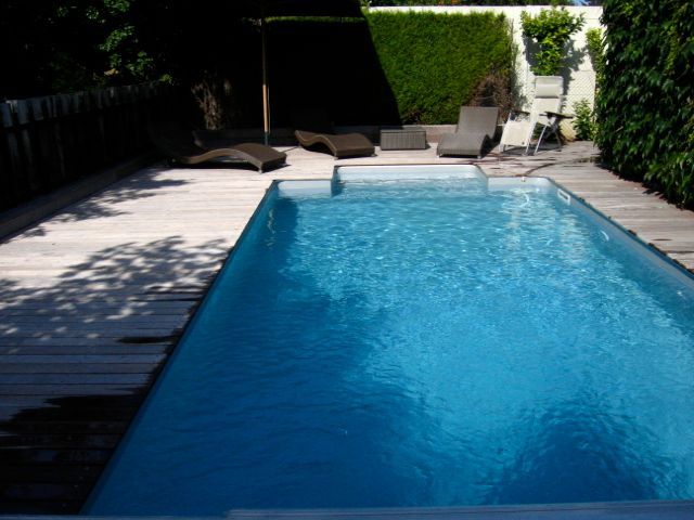 Une grande piscine entourée de chaises et de parasols