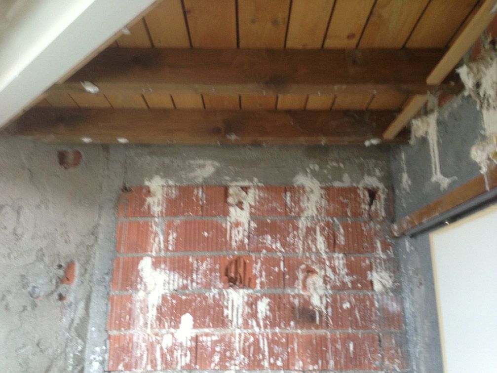 Une pièce avec un mur de briques et un plafond en bois