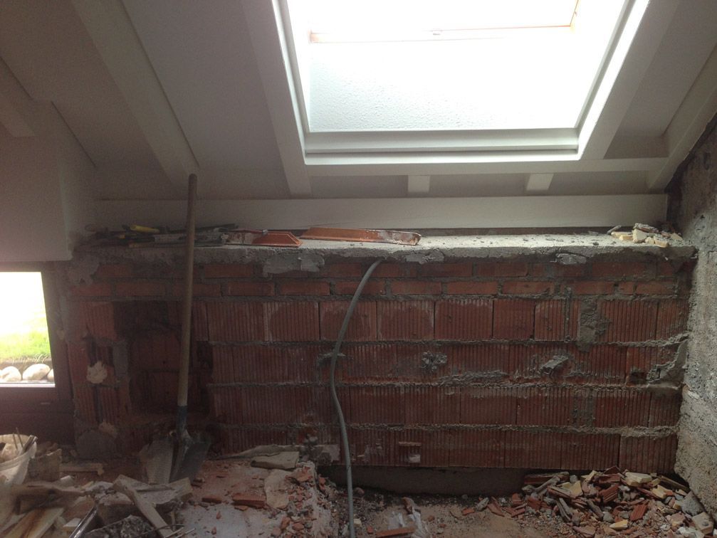 Un mur de briques avec une lucarne au-dessus