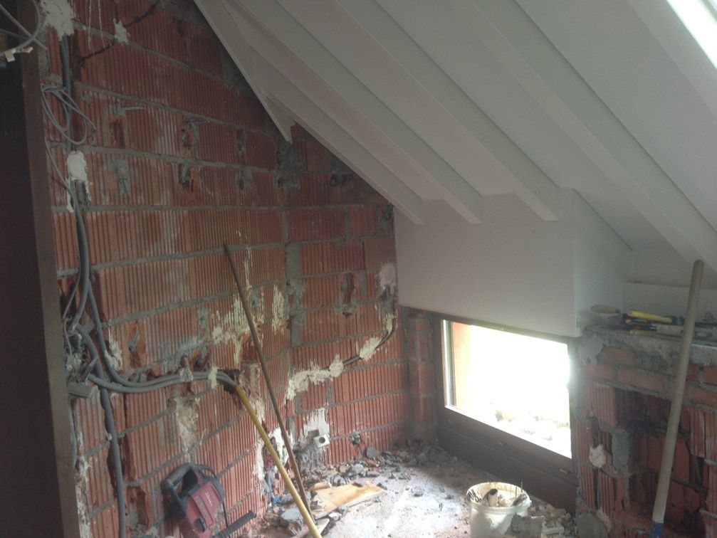 Une pièce avec un mur de briques et une fenêtre est en cours de rénovation.