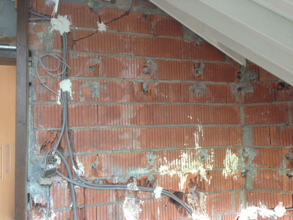 Un mur de briques avec des fils électriques qui en sortent