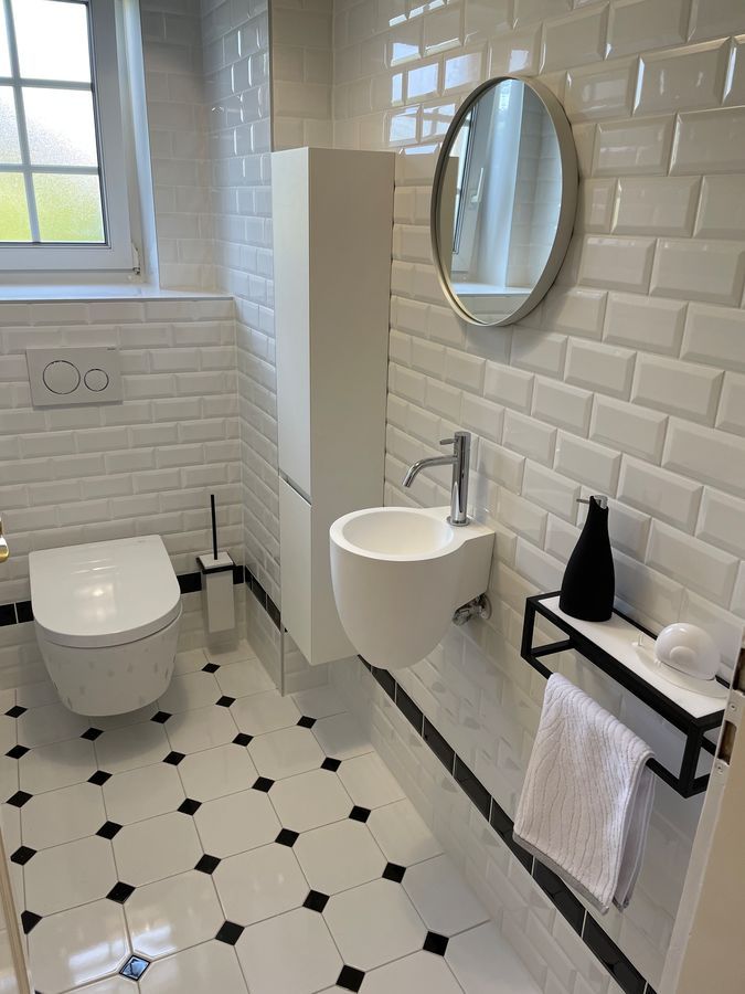 Une salle de bain avec WC, lavabo et miroir.