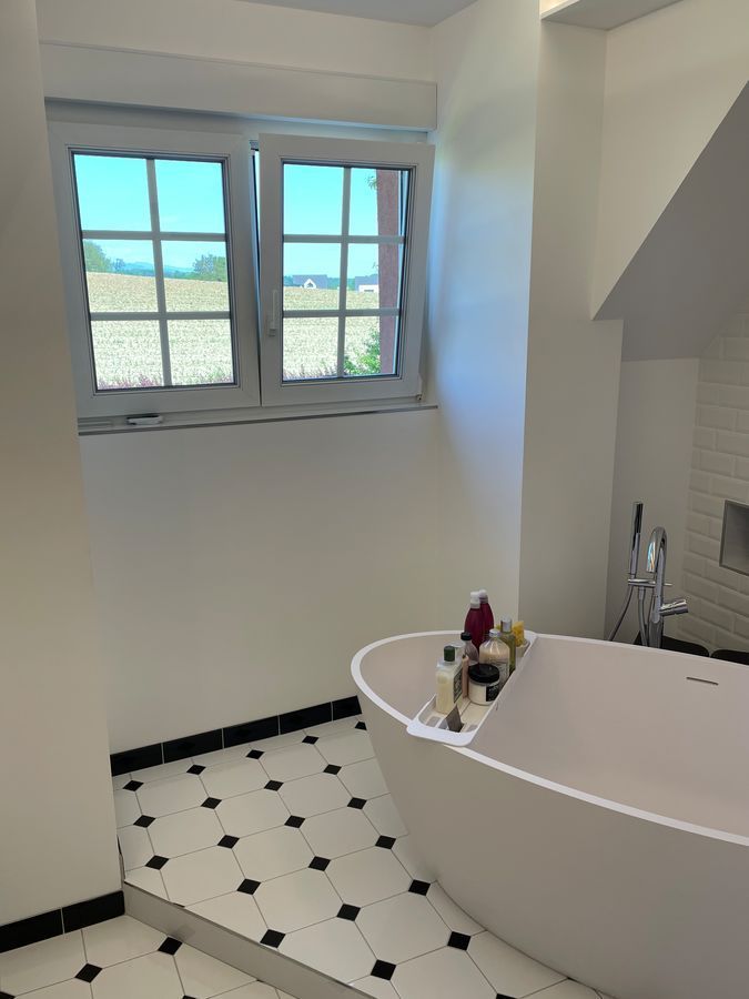 Une salle de bain avec baignoire et fenêtre.