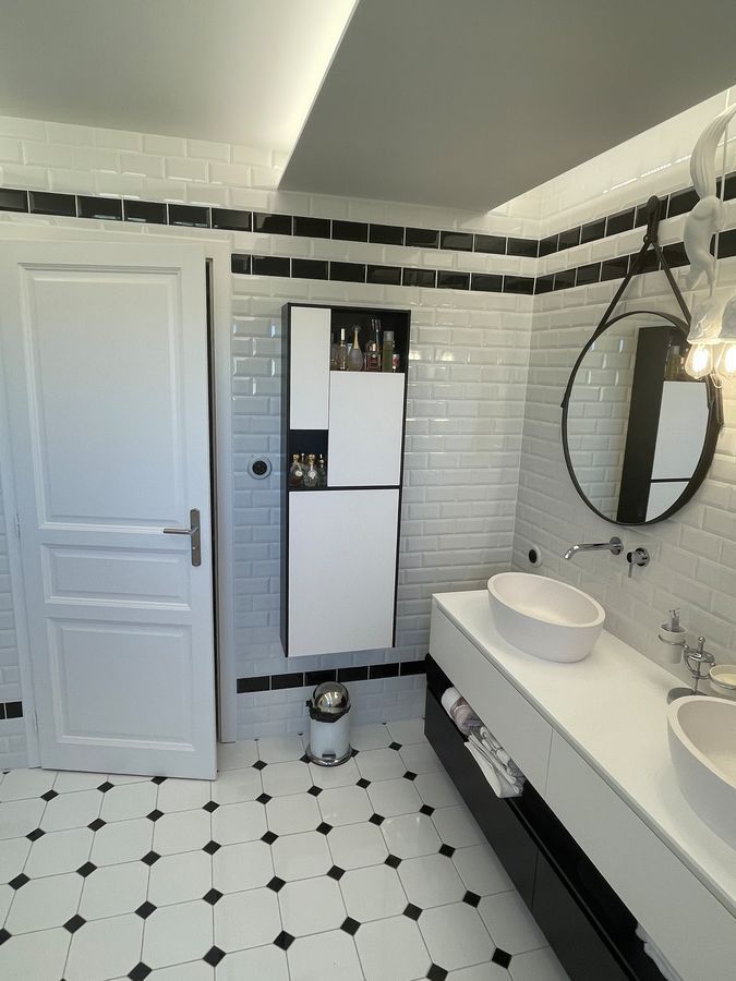 Une salle de bain avec deux lavabos et un miroir