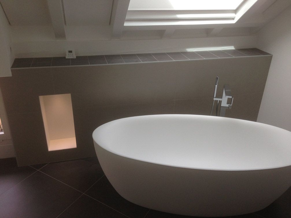 Une baignoire dans une salle de bain avec un puits de lumière au-dessus