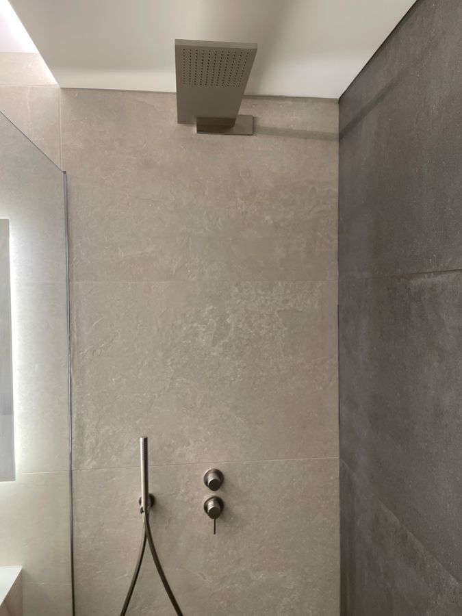 Une pomme de douche est suspendue au plafond dans une salle de bain.